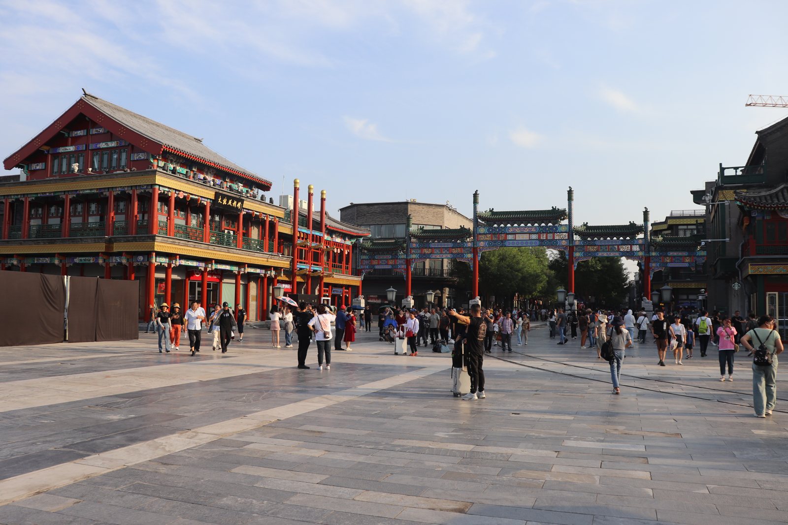 Visitors outside the gateway and traditional shop buildings of Qianmen Street in Beijing.